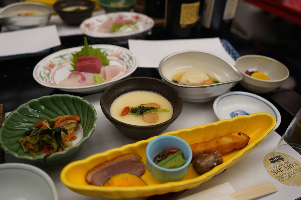Assorted famous regional foods from India including dosa, dhokla, and lassi arranged on wooden table