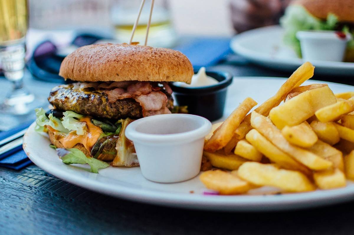 what foods cause weight gain: examples of common territory foods like fried pastries, sugary drinks, and heavy stews lined up on a kitchen counter
