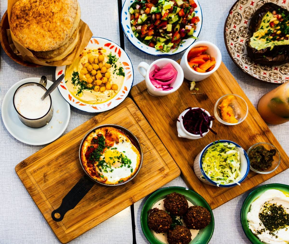 iconic foods from around the world including Oaxacan mole, Ethiopian injera, Japanese natto, and Korean kimchi arranged on a rustic wooden table